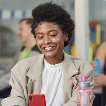 Moça sorrindo e olhando para o celular